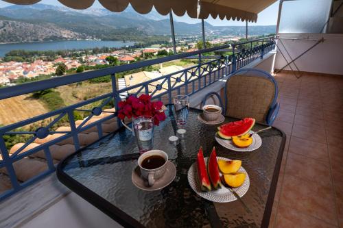 - une table avec une tasse de café et des fruits sur un balcon dans l'établissement Antigone Apartments Argostoli (Spilia) 4, à Argostóli