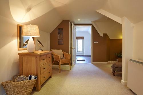 uma sala de estar com um candeeiro numa cómoda de madeira em The Den at Backwell Down em Nailsea