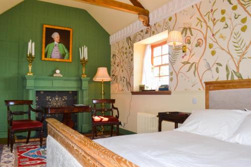 a bedroom with green walls and a bed and a fireplace at The Munches Room at Buittle Castle in Castle Douglas