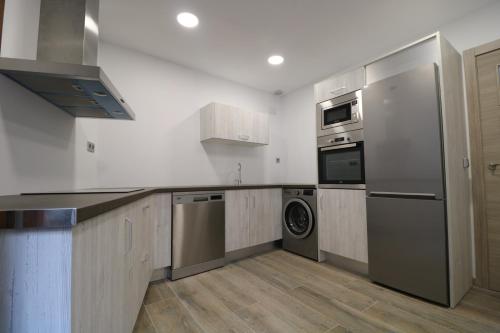 una cucina con frigorifero, lavatrice e asciugatrice di Casas Rurales Bestue-Ordesa a Bestué