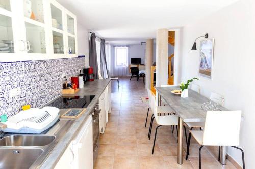 une cuisine avec un évier et une table avec des chaises dans l'établissement Rouretord Hirondelle, à Gilhac-et-Bruzac