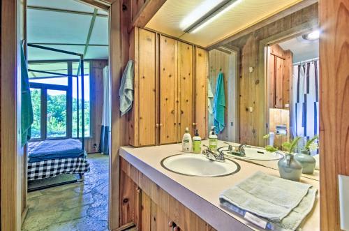 La salle de bains est pourvue d'un lavabo et d'un miroir. dans l'établissement Tranquil Mid-Century Modern Cottage with Forest View, à Hardy