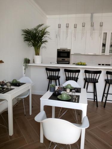 a kitchen with white tables and chairs and a counter at Vittorio Veneto Private SPA in Sulmona