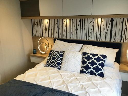 uma cama com almofadas num quarto em Southview VIP Lodge Skegness Stunning setting and location Outdoor decking area fitted to a 5 star standard em Skegness