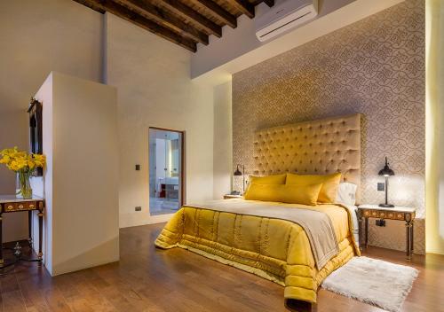 a bedroom with a yellow bed with a yellow bedspread at Casa Barroca in Puebla