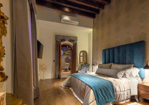 une chambre avec un grand lit et une tête de lit bleue dans l'établissement Casa Barroca, à Puebla