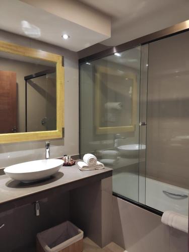 a bathroom with a sink and a glass shower at Hotel Rosario Lago Titicaca in Copacabana