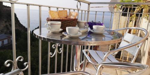 een tafel op een balkon met koffiekopjes en brood bij La Casa di Sara in Pizzo