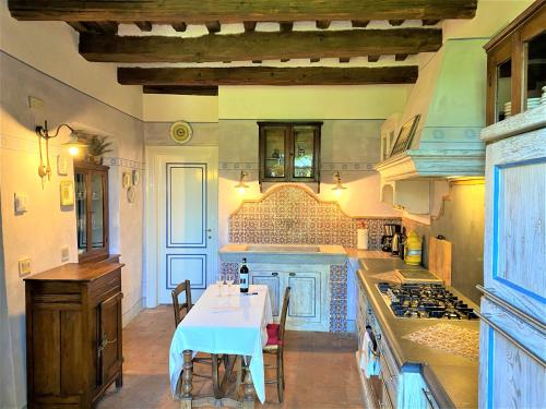uma cozinha com uma mesa e um fogão forno superior em Dimora Belvedere em Montecatini Terme