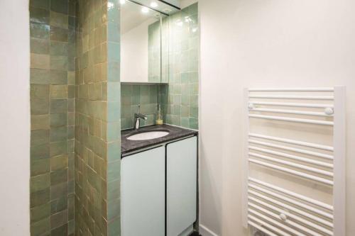 a bathroom with a sink and a mirror at CHARMING LE MARAIS RETRO in Paris