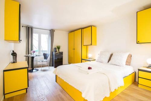 a bedroom with a large bed with yellow cabinets at CHARMING LE MARAIS RETRO in Paris
