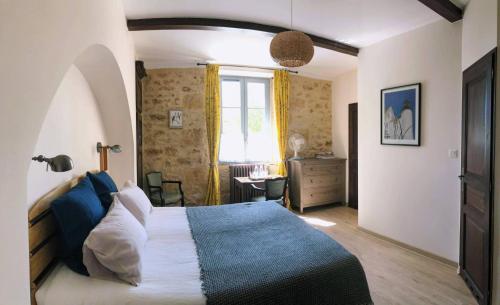 a bedroom with a large bed and a window at Le Petit Manoir de Vitrac in Vitrac