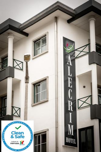 a hotel sign in front of a white building at Hotel Alecrim in Fátima