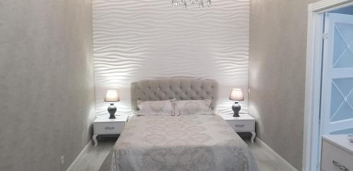 a bedroom with a bed with two nightstands and two lamps at Апартаменты Аркадия Гагарин Плаза У моря Без комиссии in Odesa