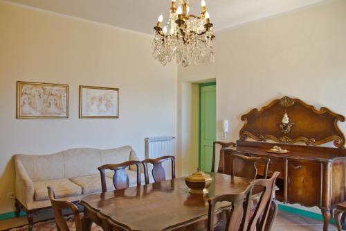 a dining room with a table and a chandelier at B&B La Residenza Torchiara in Torchiara