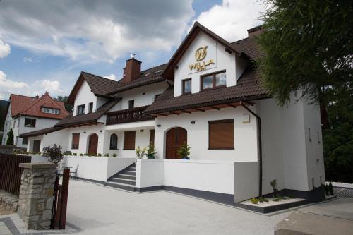 a white building with a brown roof at Willa Fen in Karpacz