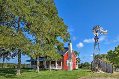 an old red house and a windmill at Peaceful Schulenburg Farmhouse with Fire Pit and Grill in Schulenburg