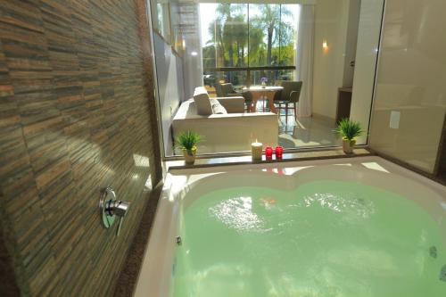 a jacuzzi tub with a view of a patio at Vivaz Cataratas Hotel Resort in Foz do Iguaçu