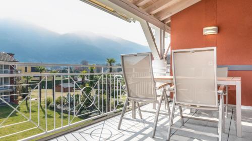 a balcony with chairs and a table and a view at Hapimag Resort Ascona in Ascona