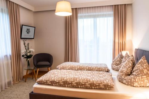 a hotel room with two beds and a window at Faustlinghof in Saalfelden am Steinernen Meer