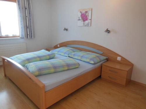 a bedroom with a wooden bed with two pillows at Haus Viola in Samnaun