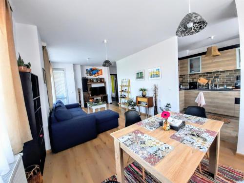 a living room with a table and a blue couch at NC Apartment Ruse in Ruse