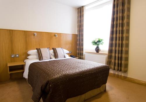 1 dormitorio con 1 cama grande y ventana en Blooms Hotel, en Dublín
