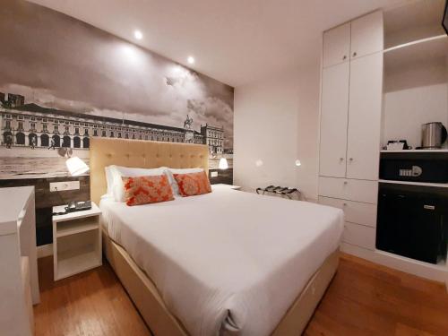 1 Schlafzimmer mit einem großen weißen Bett und einer Küche in der Unterkunft Lisbon City Apartments & Suites by City Hotels in Lissabon