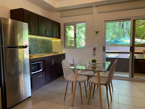 a kitchen with a table and a stainless steel refrigerator at ARANJUEZ LOFTS Santa Ana in Santa Ana