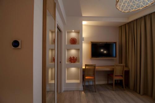 a dining room with a table and chairs and a television at Aqua Boutique Hotel in Castiglione della Pescaia