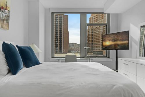 Global Luxury Suites Crystal City في أرلينغتون: غرفة نوم بيضاء مع سرير كبير ومكتب