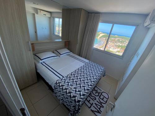 a small bedroom with a bed and a window at Blue Ocean Ponta Negra in Natal