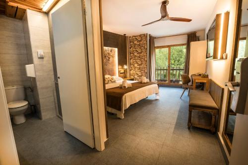 a bedroom with a bed and a toilet in a room at Hotel Restaurant Les Brases in Sort