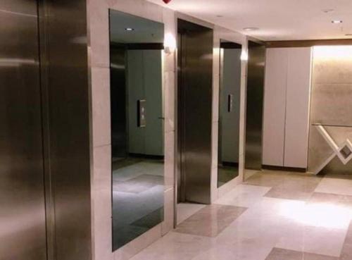 a hallway of elevators in a building with mirrors at Orbi City in Batumi