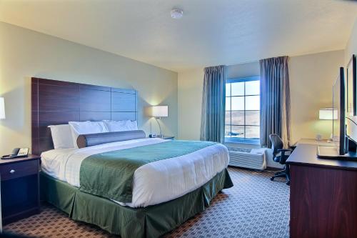 a hotel room with a large bed and a window at Cobblestone Hotel & Suites - Beulah in Beulah
