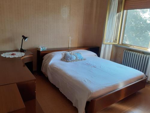 ein Schlafzimmer mit einem Bett mit einem Teddybär drauf in der Unterkunft Casa Eva in Longoio