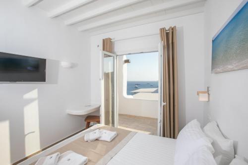 a bedroom with a bed and a view of the ocean at Seethrough Mykonos Suites in Platis Yialos Mykonos