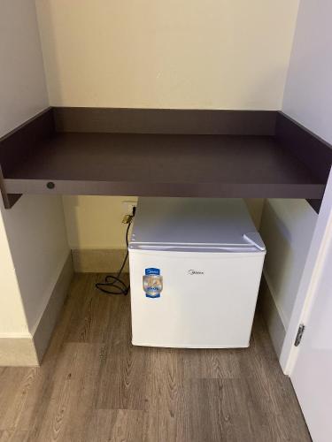 a computer under a shelf in a room at Hotel Avalon Maringá Econômico in Maringá