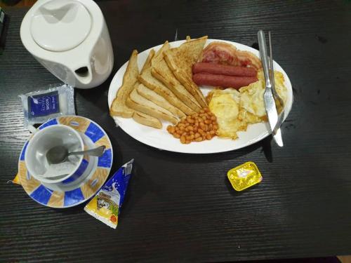 a plate of breakfast food with eggs sausage and french fries at Choice Suites II in Ikeja