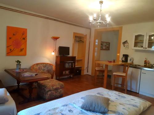 uma sala de estar com uma cama e uma mesa e uma cozinha em Axtburg Apartments em Bérbaltavár