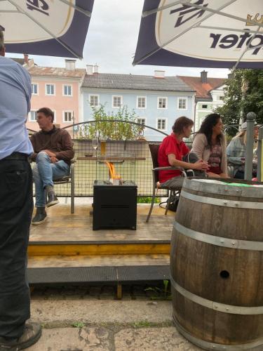 a group of people sitting on a deck with barrels at Pension Sunnseitn - Gasthof - Café - Weinkeller in Haslach an der Mühl