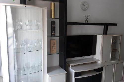 a entertainment center with wine glasses and a tv at Peñamar Apartamentos in Puerto del Carmen