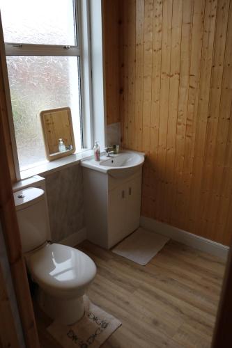 a bathroom with a toilet and a sink and a window at Lennard House in Folkestone