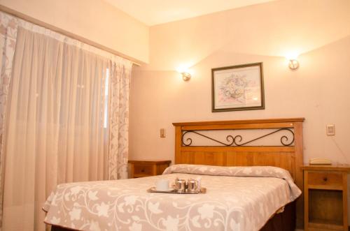 um quarto com uma cama e uma mesa com copos em Esmeralda Palace Hotel em Buenos Aires
