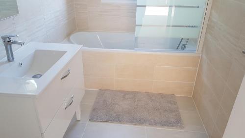 a bathroom with a tub and a sink and a shower at Maison Neuve Moderne in Fresney-le-Vieux