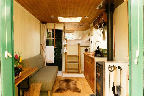 a living room with a couch and a kitchen at Abbeyfield Horsebox Glamping in Morpeth