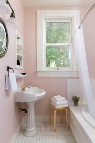a white bathroom with a sink and a window at Garden Street Inn Downtown San Luis Obispo, A Kirkwood Collection Hotel in San Luis Obispo