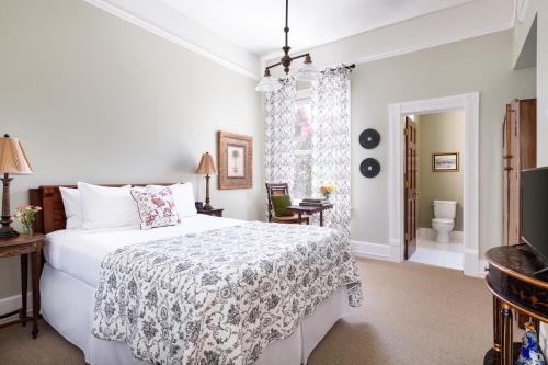 a bedroom with a white bed and a television at Garden Street Inn Downtown San Luis Obispo, A Kirkwood Collection Hotel in San Luis Obispo