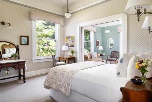 ein Schlafzimmer mit einem großen weißen Bett und einem Spiegel in der Unterkunft Garden Street Inn Downtown San Luis Obispo, A Kirkwood Collection Hotel in San Luis Obispo