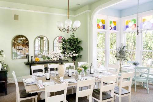 comedor con mesa, sillas y ventanas en Garden Street Inn Downtown San Luis Obispo, A Kirkwood Collection Hotel en San Luis Obispo
